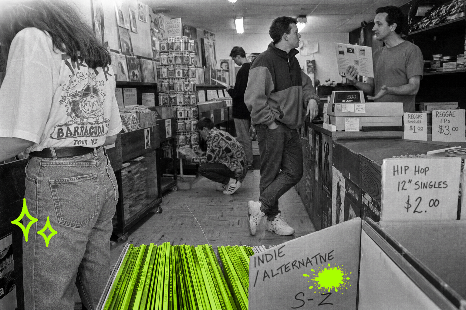 Wide black-and-white point-and-shoot interior of a 1993 independent record store. Five people browse and talk across three depth planes — a woman flips through records in the foreground, the owner chats with a customer at the counter mid-frame, two more browsers recede into the back of the shop. A cluster of vinyl record spines in the foreground bin glows with a translucent acid-green (#A8FF00) highlighter wash, the only color in the frame.